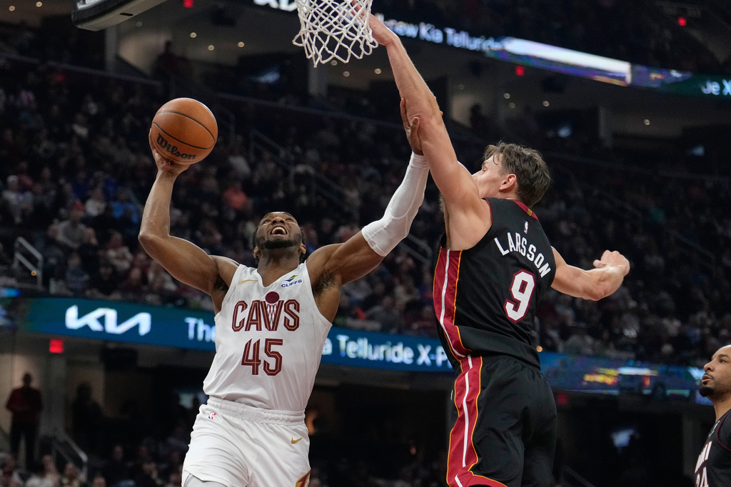 Cleveland Cavaliers guard Donovan Mitchell goes up for a shot next to Miami Heat guard Pelle Larsson (9) in the first half of an NBA basketball game in Cleveland, Wednesday, March 25, 2026. (AP Photo/Sue Ogrocki)