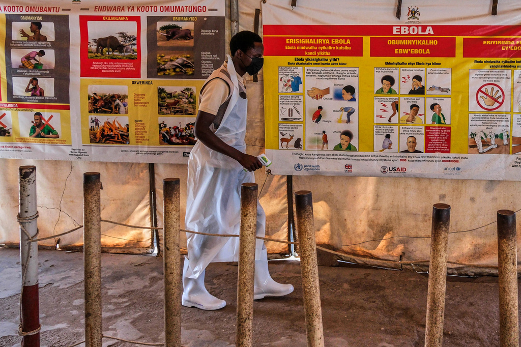A health worker walks past Ebola warning and instruction posters at a temporary health clinic at the Mpondwe border crossing linking Uganda and the Democratic Republic of the Congo, Thursday, June 4, 2026. (AP Photo/Hajarah Nalwadda)