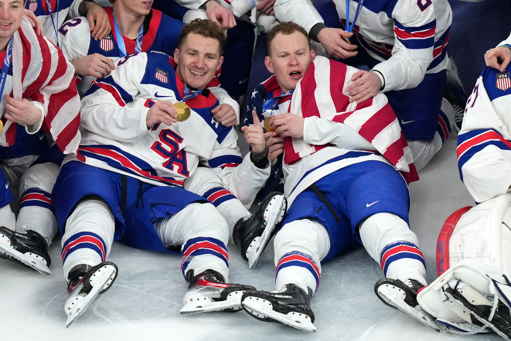 United States' Matthew Tkachuk, left, and Brady Tkachuk pose for the team picture after receiving their gold medals following an overtime win against Canada in the men's ice hockey gold medal game at the 2026 Winter Olympics in Milan, Italy, Sunday, Feb. 22, 2026. (AP Photo/Carolyn Kaster)