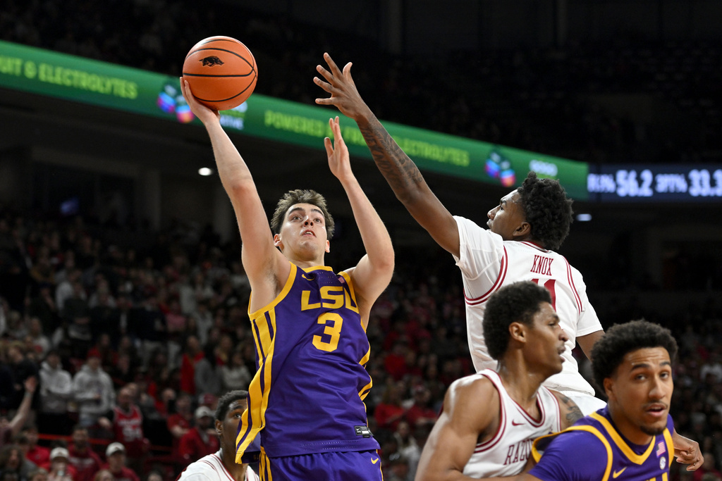 LSU guard Max Mackinnon (3) shoots over Arkansas guard Karter Knox (11) during the first half of an NCAA college basketball game Saturday, Jan. 24, 2026, in Fayetteville, Ark. (AP Photo/Michael Woods)