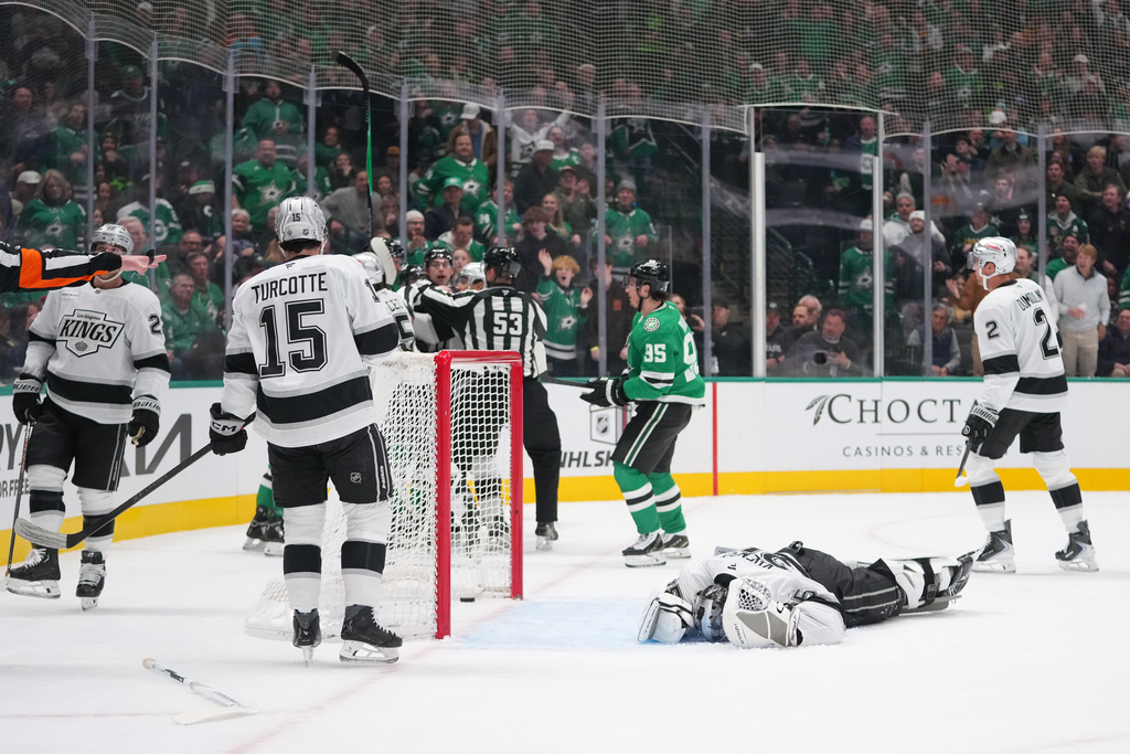 Los Angeles Kings goaltender Darcy Kuemper, bottom right, lies on the ice after a collision with Dallas Stars right wing Mikko Rantanen during the first period of an NHL hockey game Monday, Dec. 15, 2025, in Dallas. (AP Photo/Julio Cortez)