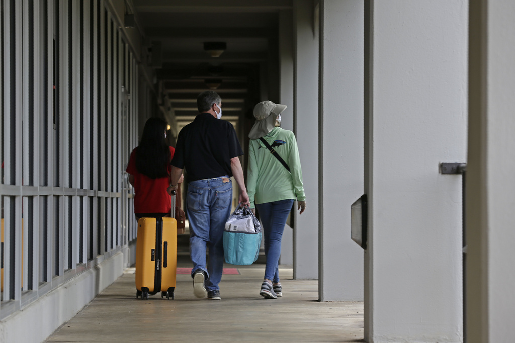 FILE - A family walks down a corridor at Lee Hall as college students begin moving in for the fall semester at N.C. State University in Raleigh, N.C., July 31, 2020. (AP Photo/Gerry Broome, File)