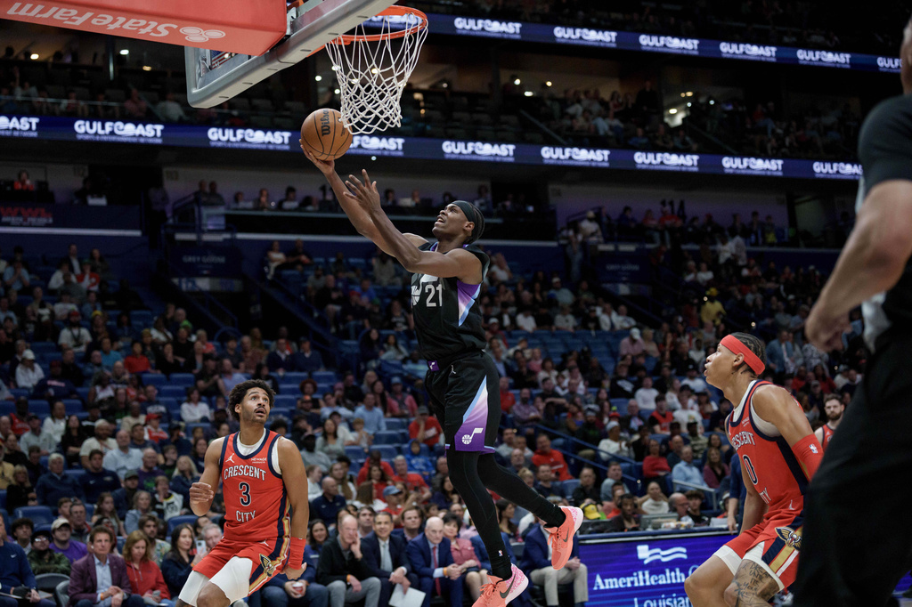 Utah Jazz guard Bez Mbeng (21) shoots against New Orleans Pelicans guard Jordan Poole (3) of an NBA basketball game in New Orleans, Tuesday, April 7, 2026. (AP Photo/Matthew Hinton)