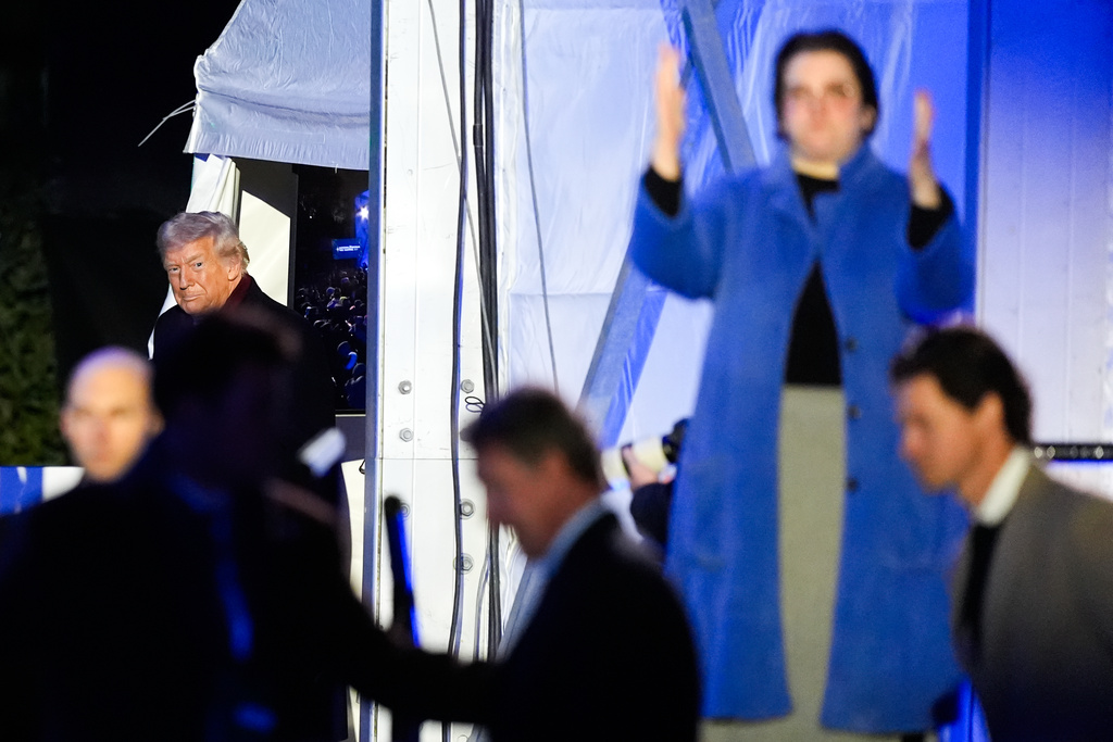 An American Sign Language interpreter, right, signs as President Donald Trump arrives for the lighting of the National Christmas Tree on the Ellipse, Thursday, Dec. 4, 2025, near the White House in Washington. (AP Photo/Julia Demaree Nikhinson)