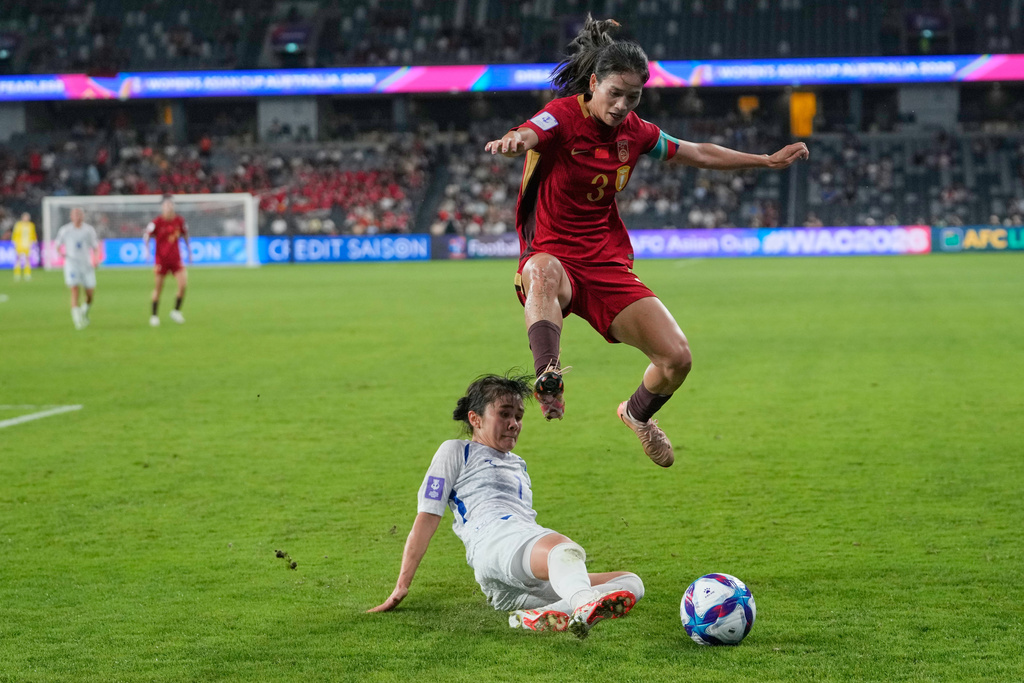 China's Chen Qiaozhu leaps over Uzbekistan's Nilufar Kudratova as they compete for the ball during the Women's Asian Cup soccer match between Uzbekistan and China in Sydney, Friday, March 6, 2026. (AP Photo/Rick Rycroft)