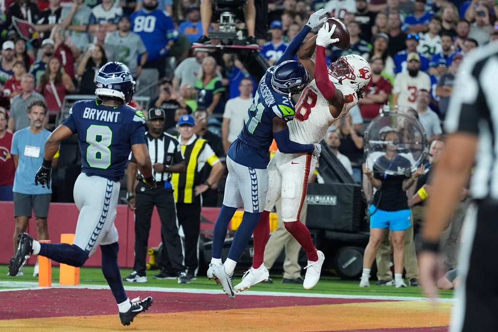 Arizona Cardinals wide receiver Marvin Harrison Jr., right, catches a touchdown pass as Seattle Seahawks cornerback Devon Witherspoon and safety Coby Bryant (8) defend during the second half of an NFL football game Thursday, Sept. 25, 2025, in Glendale, Ariz. (AP Photo/Ross D. Franklin)