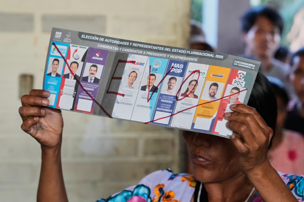 An electoral official shows a null vote that has "Evo" — referring to former President Evo Morales who is barred from running — written on it, as they count votes after polls closed for general elections in Entre Rios, Chapare region, Bolivia, Sunday, Aug. 17, 2025. (AP Photo/Jorge Saenz)