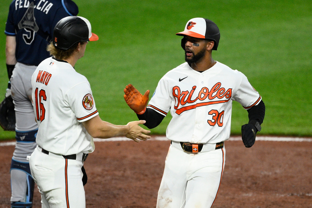 Baltimore Orioles' Leody Taveras, right, is greeted by Coby Mayo, left, after they both scored on a double by Blaze Alexander during the fifth inning of a baseball game against the Tampa Bay Rays, Wednesday, May 27, 2026, in Baltimore. (AP Photo/Nick Wass)