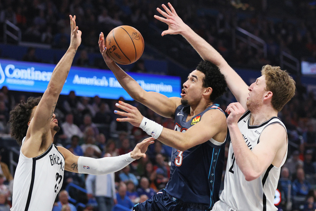 Oklahoma City Thunder guard Jared McCain (3) looks to score between Brooklyn Nets forwards Jalen Wilson, left, and Danny Wolf, right, during the second half of an NBA basketball game Friday, Feb. 20, 2026, in Oklahoma City. (AP Photo/Nate Billings)