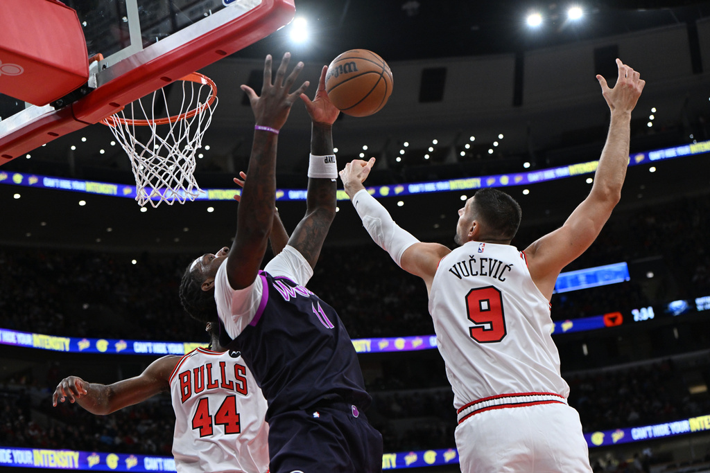 Chicago Bulls' Nikola Vucevic (9) battles Minnesota Timberwolves' Naz Reid (11) for a rebound during the first half of an NBA basketball game Monday, Dec. 29, 2025, in Chicago. (AP Photo/Paul Beaty)