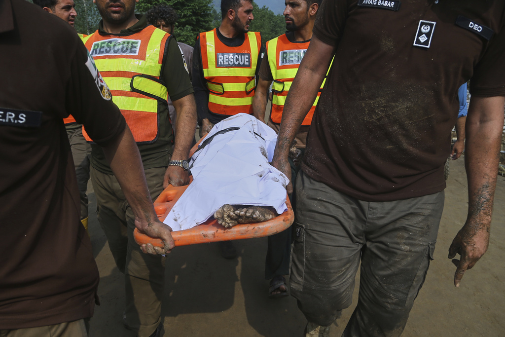 Rescue workers transport the body of a victim of Friday's flash flooding after recovering it from the rubble of a damaged house at Qadir Nagar village near Pir Baba, Buner district, in Pakistan's northwest, Saturday, Aug. 16, 2025. (AP Photo/Muhammad Sajjad)