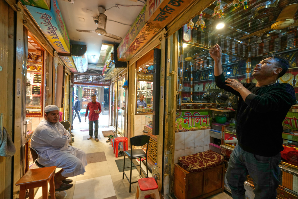 A Hindu prays as he opens his shop at a market in Dhaka, Bangladesh, Tuesday, Feb. 10, 2026. (AP Photo/Anupam Nath)