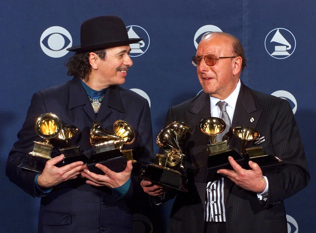 FILE - Carlos Santana, left, and producer Clive Davis pose with their Grammys at the 42nd Grammy Awards in Los Angeles, on Feb. 23, 2000. (AP Photo/Reed Saxon, File)
