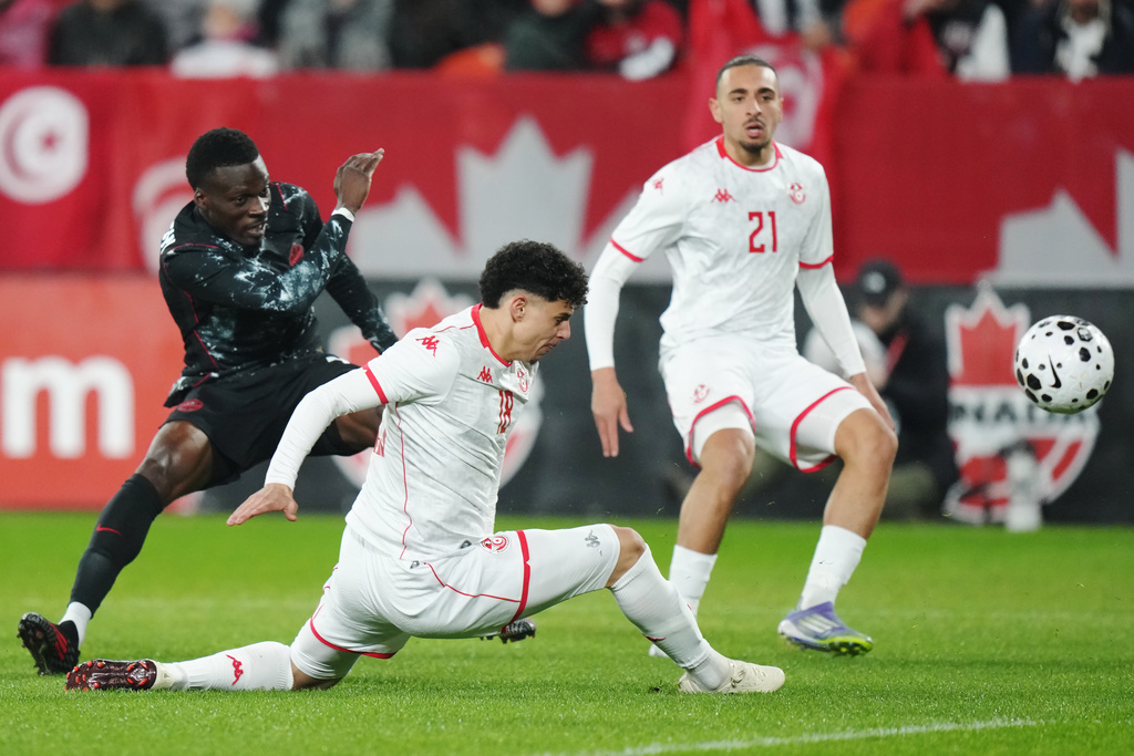 Canada's Tani Oluwaseyi, left, shoots as Tunisia's Alaa Ghram (18) and Moutaz Neffati (21) defend during the first half of an international friendly soccer match in Toronto, on Tuesday, March 31, 2026. (Chris Young/The Canadian Press via AP)