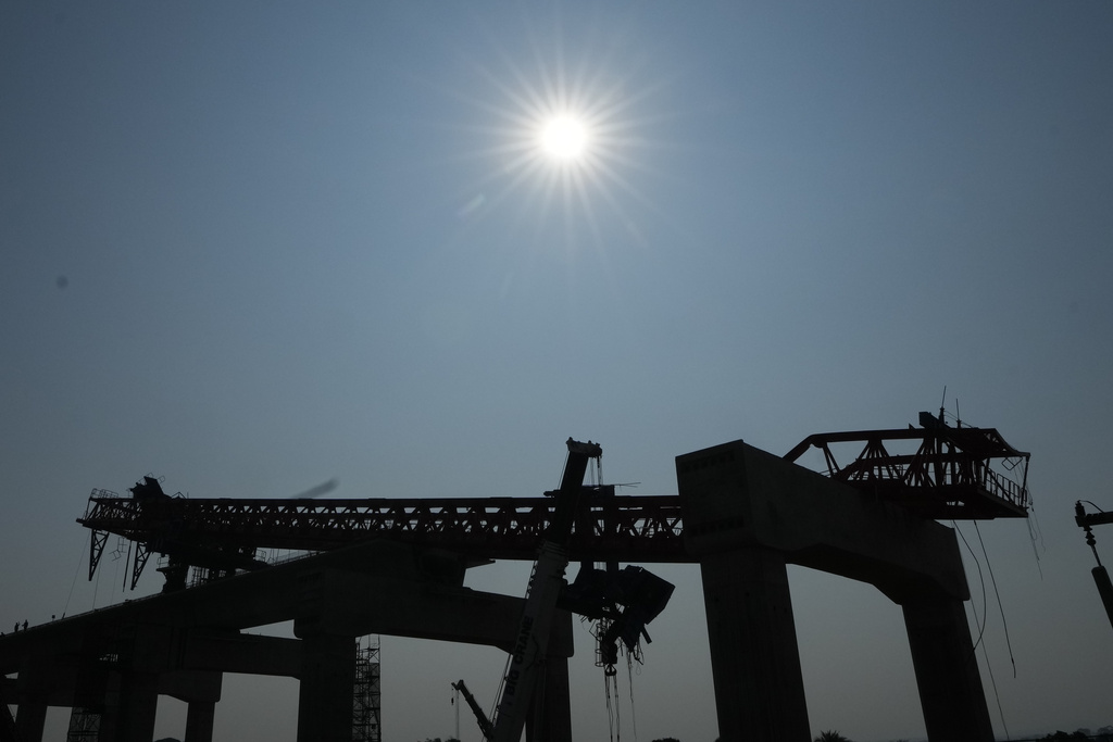 The construction site with crane wreckage is silhouetted, a day after the crane fell into a passenger train in Nakhon Ratchasima province, Thailand, Thursday, Jan. 15, 2026. (AP Photo/Sakchai Lalit)