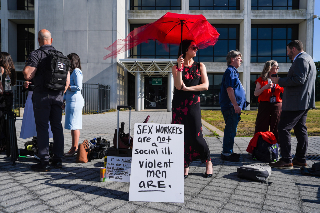 Natile Dilea, a member of a sex-workers rights group, stands in line to enter the Arthur M. Cromarty Criminal Court Complex ahead of a court sentencing for convicted murderer, Rex Heuermann, Wednesday, June 17, 2026, in Suffolk County, New York. (AP Photo/Ryan Murphy)