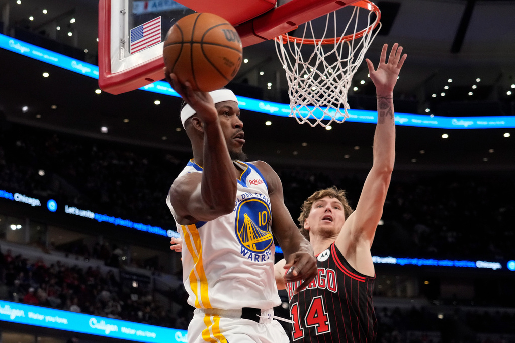 Golden State Warriors forward Jimmy Butler III, left, is defended by Chicago Bulls forward Matas Buzelis, right, during the second half of an NBA basketball game Sunday, Dec. 7, 2025, in Chicago. (AP Photo/David Banks)