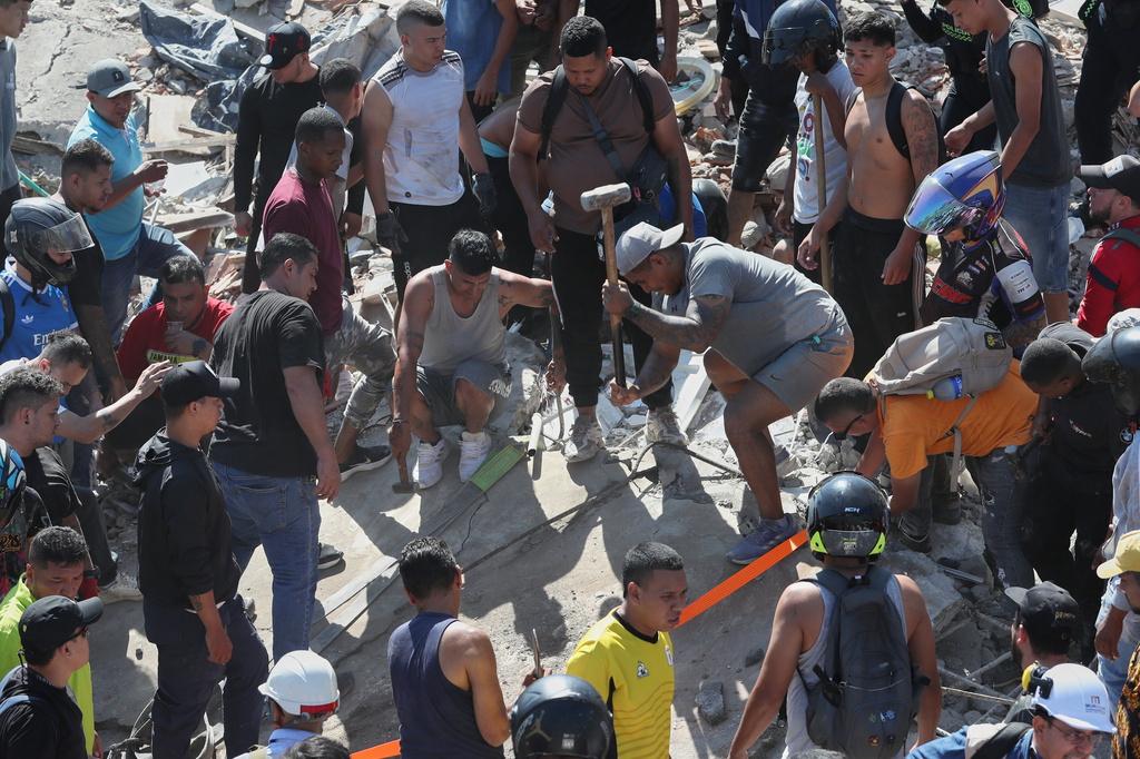 Residents search for survivors in the rubble after an earthquake struck Cali, Colombia, Monday, Aug. 10, 2026. (AP Photo/Santiago Saldarriaga)