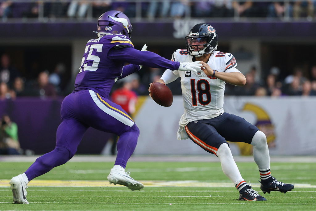 Chicago Bears quarterback Caleb Williams (18), right, looks to pass as Minnesota Vikings linebacker Eric Wilson (55) defends during the first half of an NFL football game, Sunday, Nov. 16, 2025, in Minneapolis. (AP Photo/Matt Krohn)