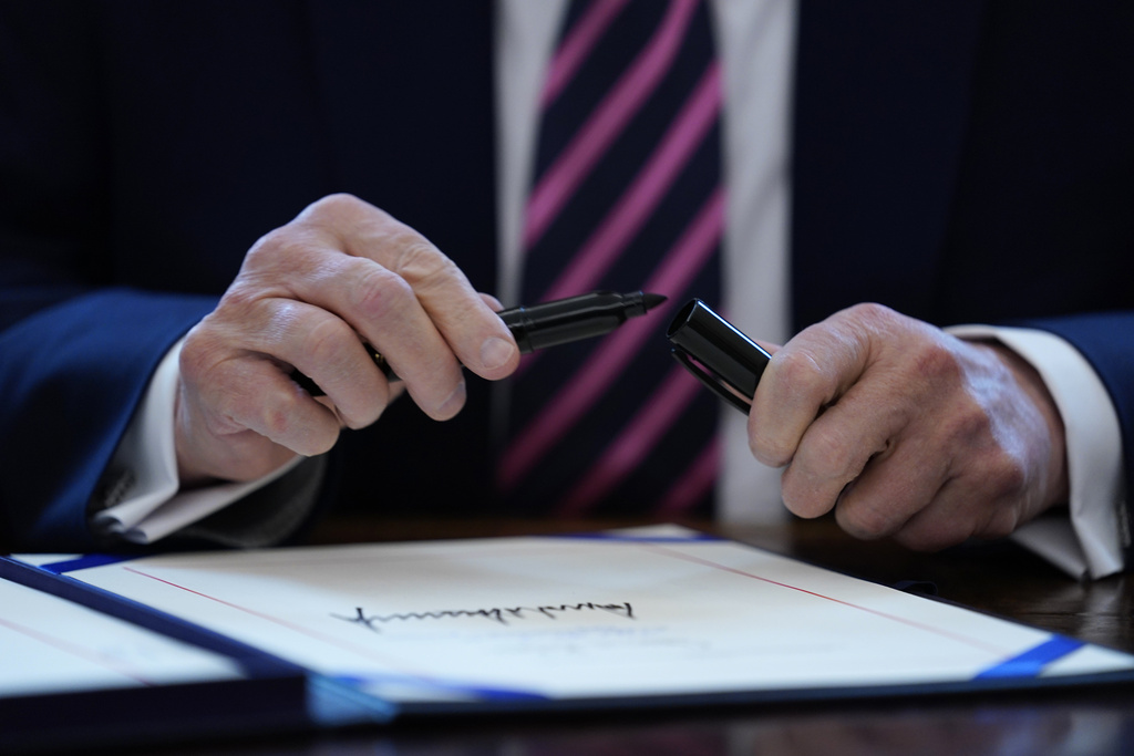 FILE - President Donald Trump puts the cap on a pen after signing a coronavirus aid package to direct funds to small businesses, hospitals, and testing, in the Oval Office of the White House, Friday, April 24, 2020, in Washington. (AP Photo/Evan Vucci, File)
