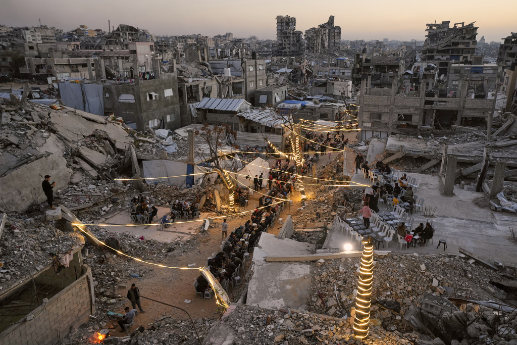 Palestinians gather for iftar, the fast-breaking meal, during the Muslim holy month of Ramadan amid the rubble of destroyed buildings in Gaza City, Sunday, Feb. 22, 2026. (AP Photo/Jehad Alshrafi)
