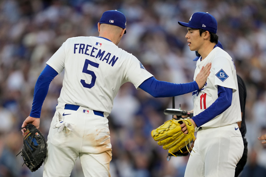 Los Angeles Dodgers pitcher Roki Sasaki and first baseman Freddie Freeman celebrate their win against the Milwaukee Brewers in Game 3 of baseball's National League Championship Series, Thursday, Oct. 16, 2025, in Los Angeles. (AP Photo/Ashley Landis)