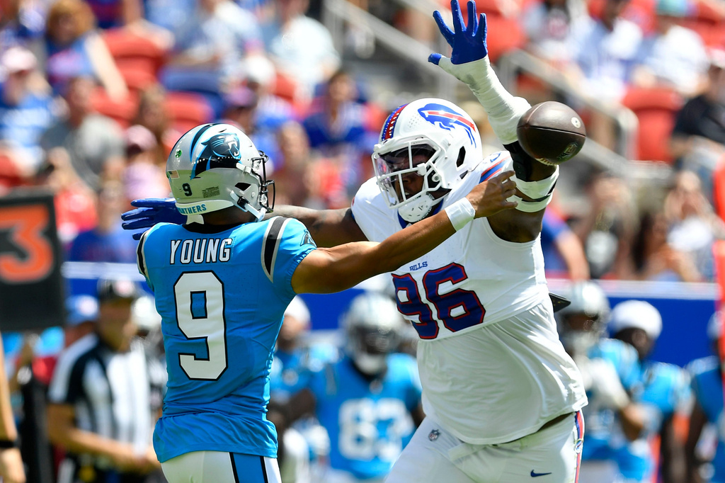 Carolina Panthers quarterback Bryce Young (9) passes around Buffalo Bills defensive tackle Deone Walker (96) during the first half of a preseason NFL football game, Saturday, Aug. 15, 2026, in Orchard Park, N.Y. (AP Photo/Adrian Kraus)
