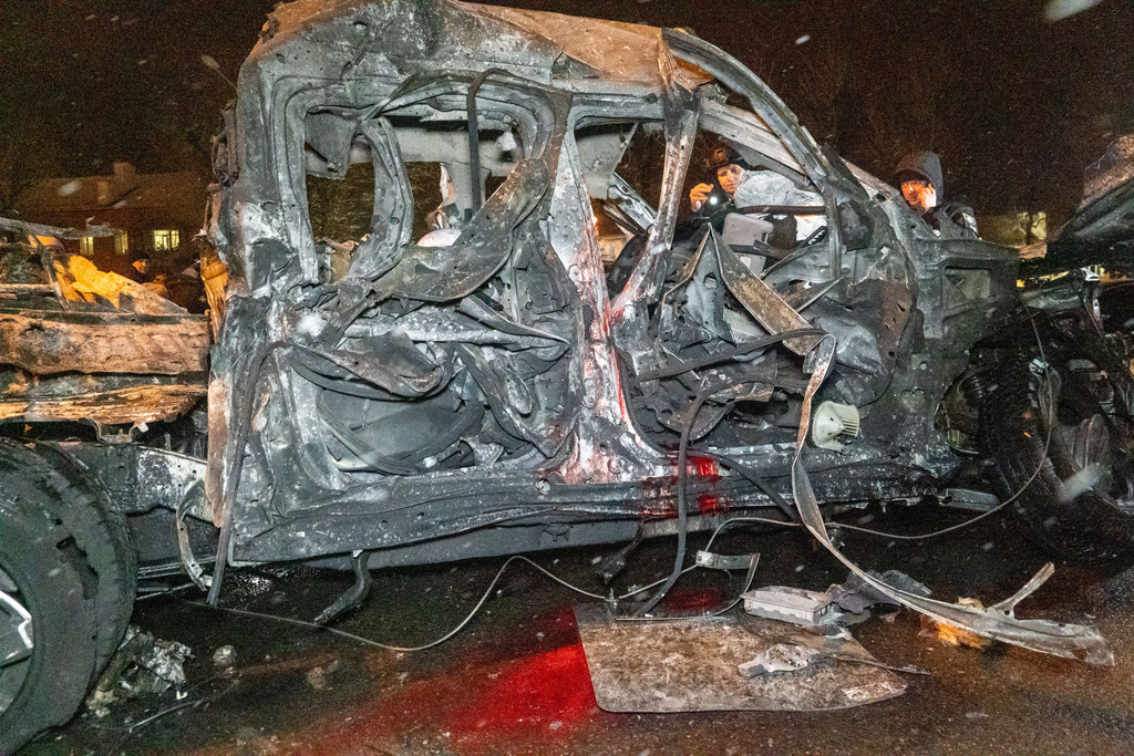 Police officers inspect the damaged vehicle hit by Russian airstrike in Kharkiv, Ukraine, Friday, Dec. 26, 2025. (AP Photo/Andrii Marienko)