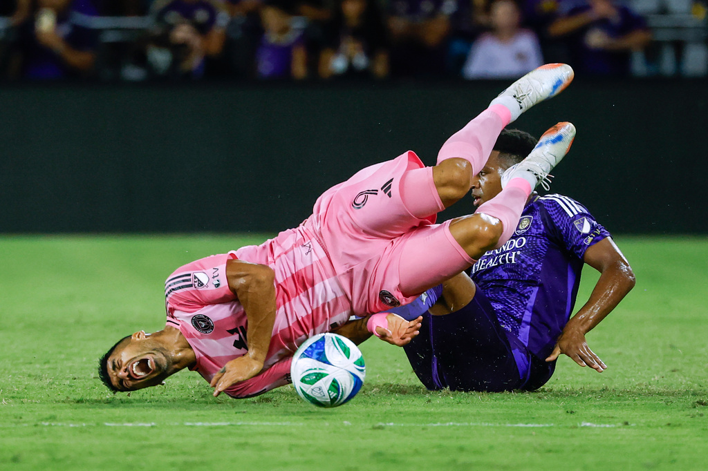 Orlando City defender Alex Freeman, right, slides into Inter Miami forward Luis Suárez (9) during the first half of an MLS soccer match Sunday, Aug. 10, 2025, in Orlando, Fla. (AP Photo/Kevin Kolczynski)