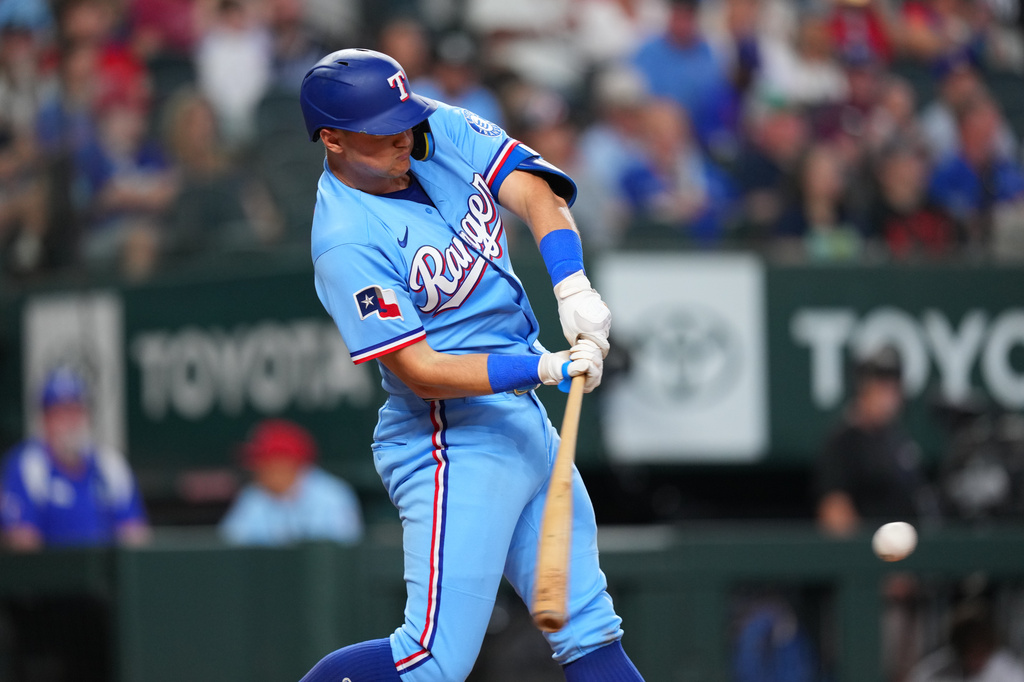 Texas Rangers' Josh Jung connects for a bases loaded single to score Kyle Higashioka and Nicky Lopez during the fourth inning of a baseball game Sunday, May 31, 2026, in Arlington. (AP Photo/Julio Cortez)