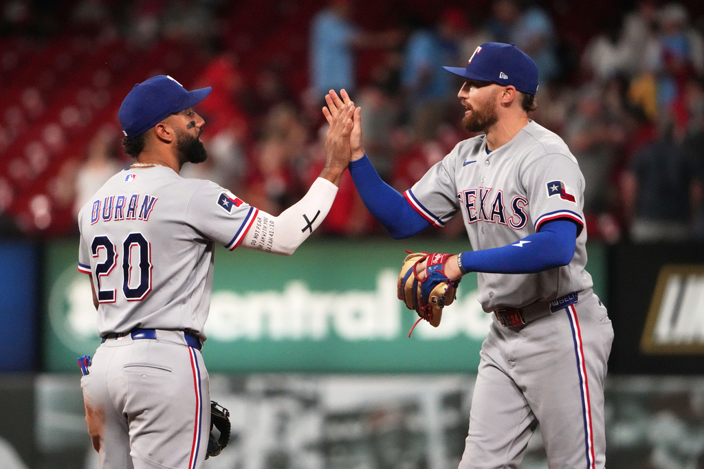 Texas Rangers' Ezequiel Duran (20) and Brandon Nimmo celebrate a victory over the St. Louis Cardinals in a baseball game Monday, June 1, 2026, in St. Louis. (AP Photo/Jeff Roberson)