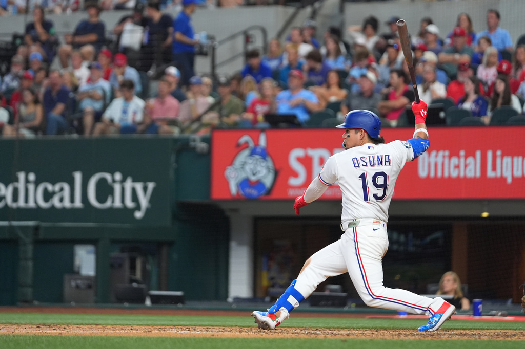 Texas Rangers' Alejandro Osuna follows through on a swing as he hits an RBI single to score Joc Pederson during the fourth inning of a baseball game against the Chicago Cubs, Saturday, May 9, 2026, in Arlington, Texas. (AP Photo/Julio Cortez)