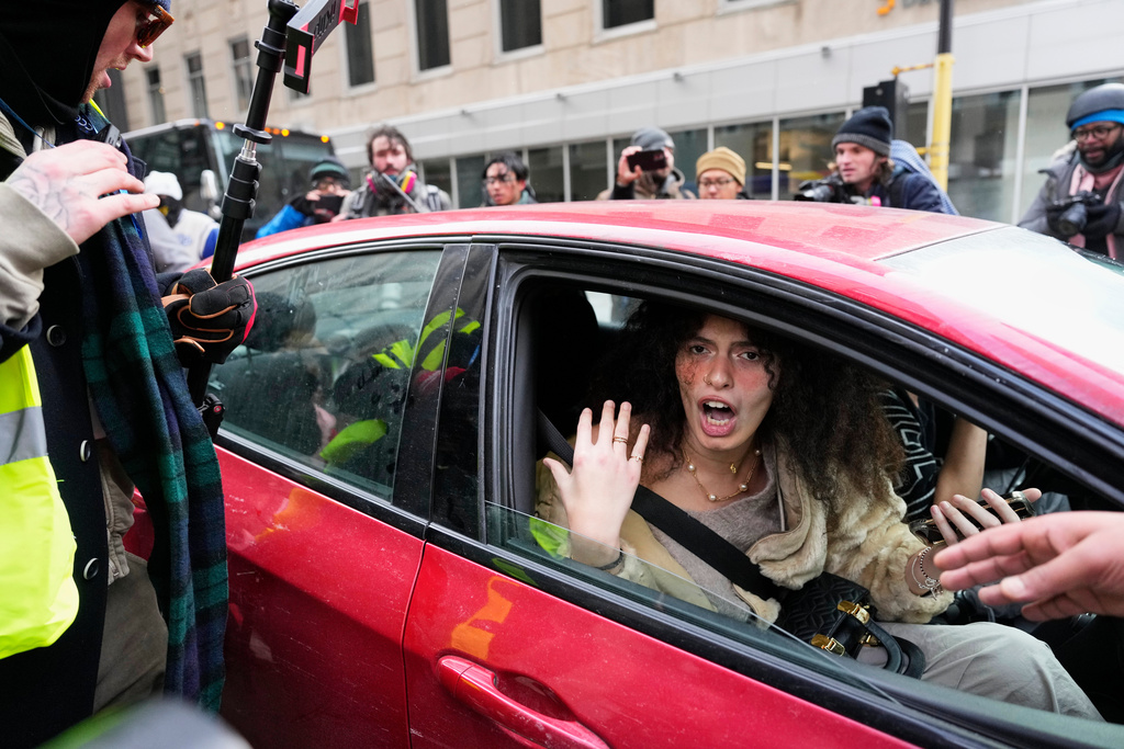 Jake Lang, who organized the protest March Against Minnesota Fraud, leaves the rally by getting into a car near Minneapolis City Hall, Saturday, Jan. 17, 2026, in Minneapolis. (AP Photo/Yuki Iwamura)