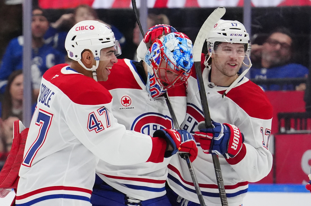 Montréal Canadiens defenseman Jayden Struble (47), goaltender Jakub Dobes, center, and Josh Anderson (17) celebrate winning over the Toronto Maple Leafs after a shootout in an NHL hockey game in Toronto, Saturday, Dec. 6, 2025. (Frank Gunn/The Canadian Press via AP)