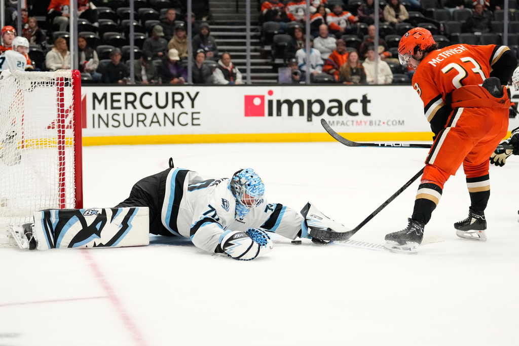 Utah Mammoth goaltender Karel Vejmelka, left, stops a shot by Anaheim Ducks center Mason McTavish during the third period of an NHL hockey game Wednesday, Dec. 3, 2025, in Anaheim, Calif. (AP Photo/Mark J. Terrill)