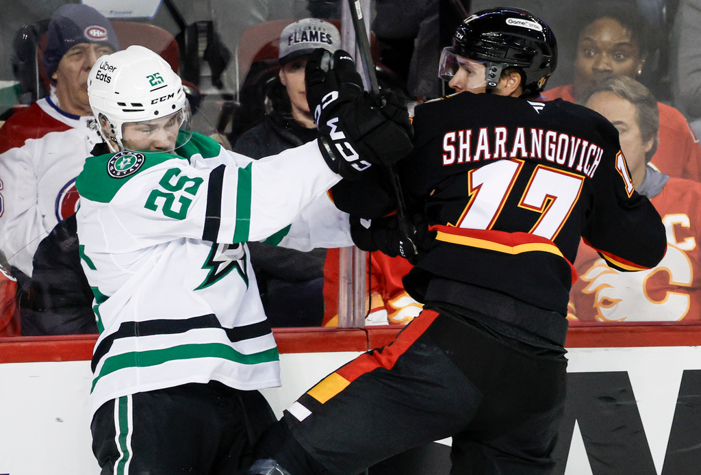 Dallas Stars' Arttu Hyry, left, checks Calgary Flames' Yegor Sharangovich during the second period of an NHL hockey game in Calgary, Alberta on Tuesday, March 3, 2026. (Jeff McIntosh/The Canadian Press via AP)