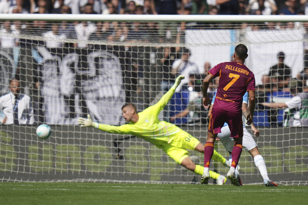 Roma's Lorenzo Pellegrini scores his side's opening goal past Lazio's goalkeeper Ivan Provedel during an Italian Serie A soccer match between Lazio and Roma, at the Olimpic Stadium, in Rome, Italy, Sunday, Sept. 21, 2025. (AP Photo/Alessandra Tarantino)
