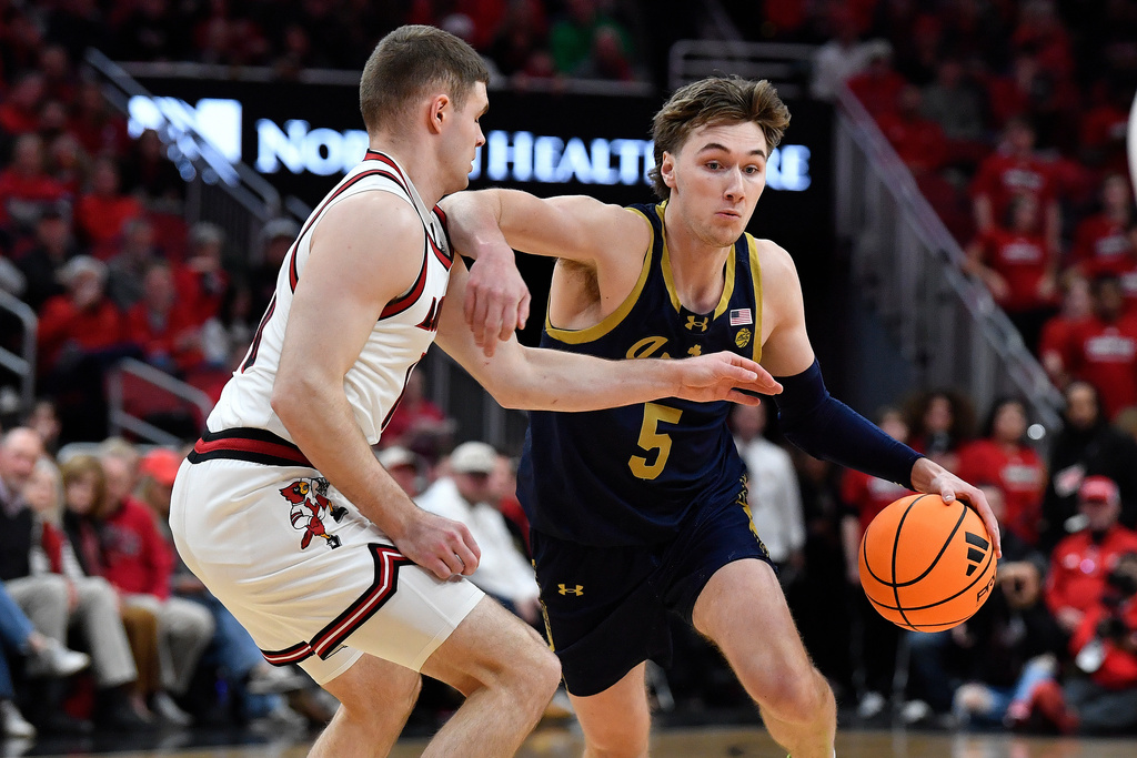 Notre Dame guard Cole Certa (5) attempts to drive past Louisville guard Isaac McKneely (10) during the first half of an NCAA college basketball game in Louisville, Ky., Wednesday, Feb. 4, 2026. (AP Photo/Timothy D. Easley)