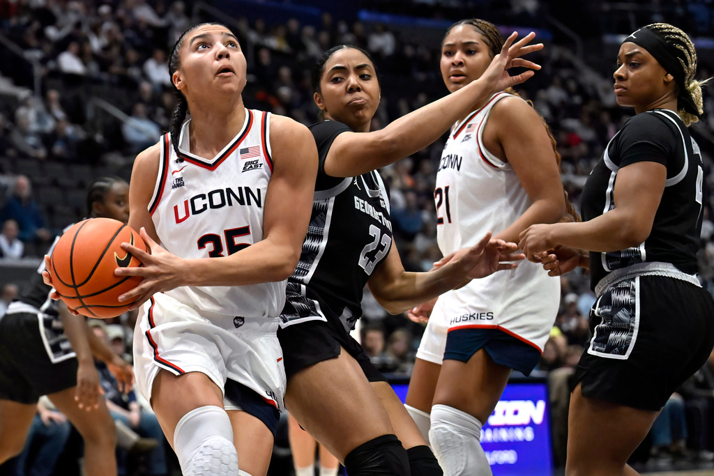 UConn guard Azzi Fudd, left, looks to shoot as Georgetown guard Summer Davis (23) defends in the first half of an NCAA college basketball game, Thursday, Feb. 26, 2026, in Hartford, Conn. (AP Photo/Jessica Hill)