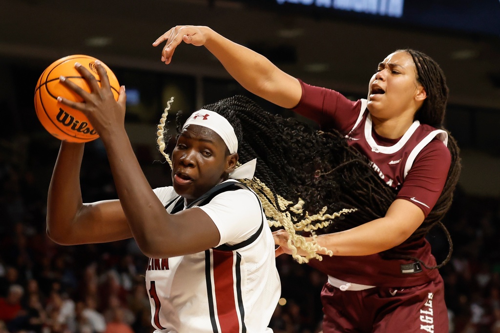 South Carolina center Madina Okot, left, pulls down an offensive rebound against North Carolina Central forward Dianna Blake during the first half of an NCAA college basketball game in Columbia, S.C., Sunday, Dec. 7, 2025. (AP Photo/Nell Redmond)
