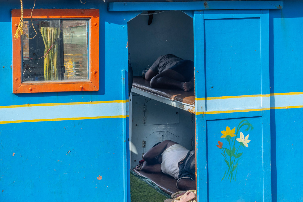 Fishermen nap inside their boat anchored at Sassoon Dock in Mumbai, India, Tuesday, April 7, 2026. (AP Photo/Rafiq Maqbool)