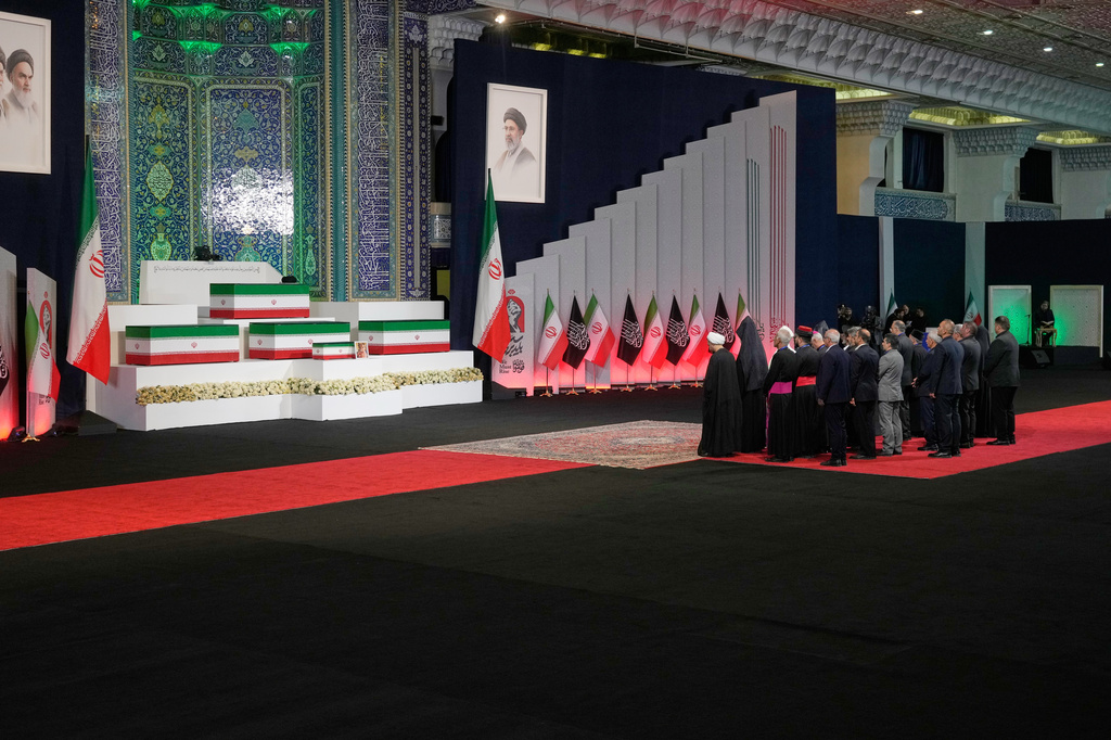 Iranian religious leaders and other mourners pay their respects before the coffins of slain Iranian Supreme Leader Ayatollah Ali Khamenei and members of his family during a viewing ceremony ahead of the dayslong funeral ceremonies at the Imam Khomeini Mosalla Grand Mosque in Tehran, Iran, Friday, July 3, 2026. (AP Photo/Vahid Salemi)
