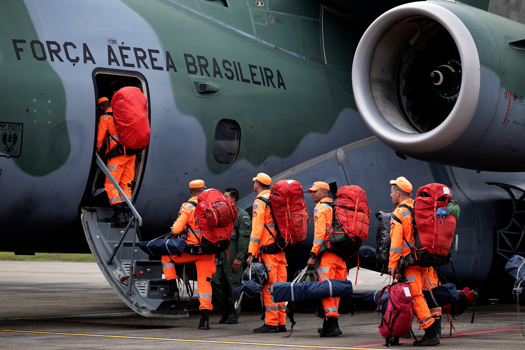 Brazilian military firefighters board a Brazilian Air Force aircraft before departing on a humanitarian mission to assist victims of the doublet in earthquakes in Venezuela at the Guarulhos Air Base in Sao Paulo, Brazil, Friday, June 26, 2026. (AP Photo/Ettore Chiereguini)