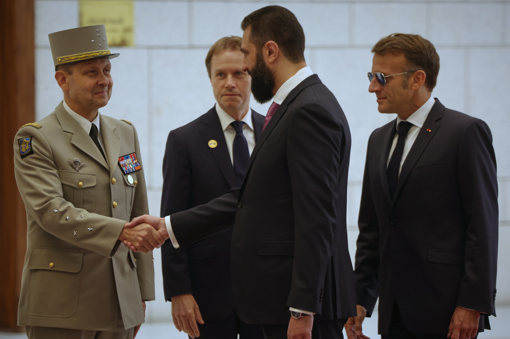 Syrian President Ahmad al-Sharaa, center, shakes hands with Gen. Vincent Giraud, Macron's Chief of Staff, as French President Emmanuel Macron, right, as they meet in Damascus, Syria, Tuesday, July 7, 2026. (AP Photo/Omar Albam)(AP Photo/Ghaith Alsayed)