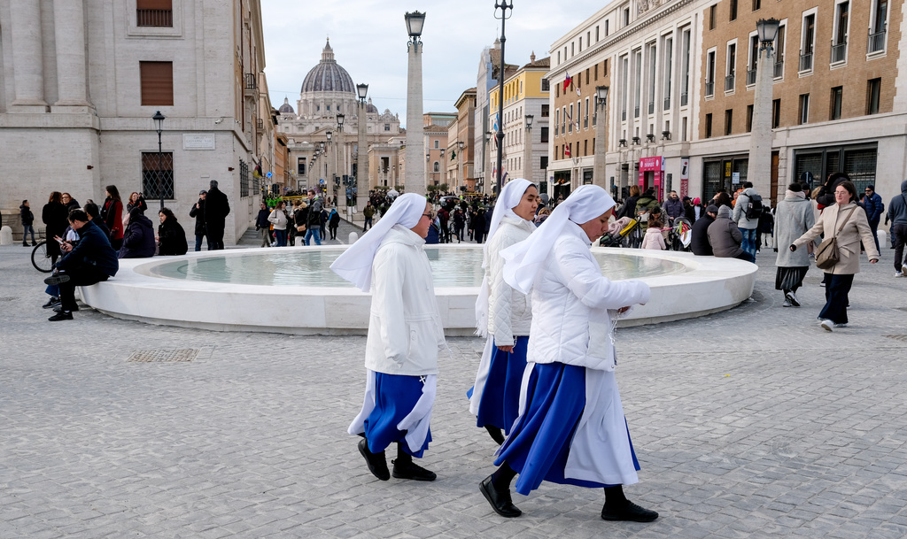 FILE - Nuns walk past a fountain after the inauguration of the new design of Piazza Pia, a pedestrian piazza at the end of the Via della Conciliazione boulevard, opposite St. Peter's Basilica, Thursday, Dec. 26, 2024. (Mauro Scrobogna/LaPresse via AP, file)