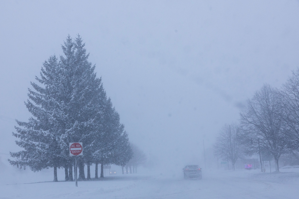 Vehicles are driven through whiteout conditions along Lake Michigan Drive during a winter storm warning in Ottawa County, Mich. on Monday, Jan. 19, 2026. (Joel Bissell/Kalamazoo Gazette via AP)