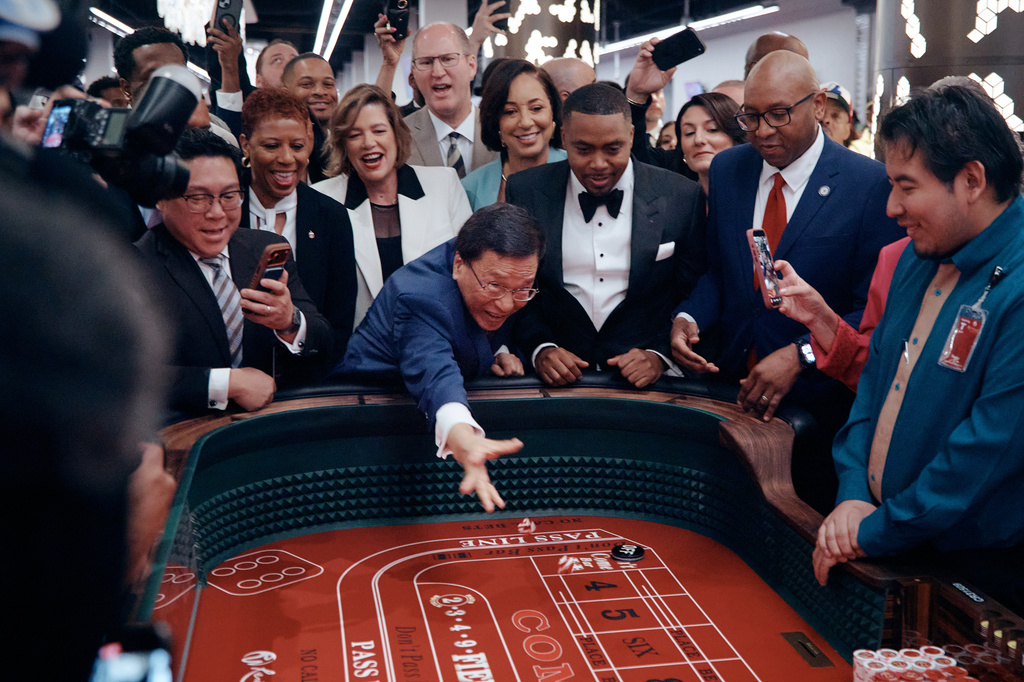 Lim Kok Thay, CEO of Genting Group, center, throws ceremonial dice during the opening of live table games at Resorts World New York City on Tuesday, April 28, 2026, in New York. (AP Photo/Andres Kudacki)