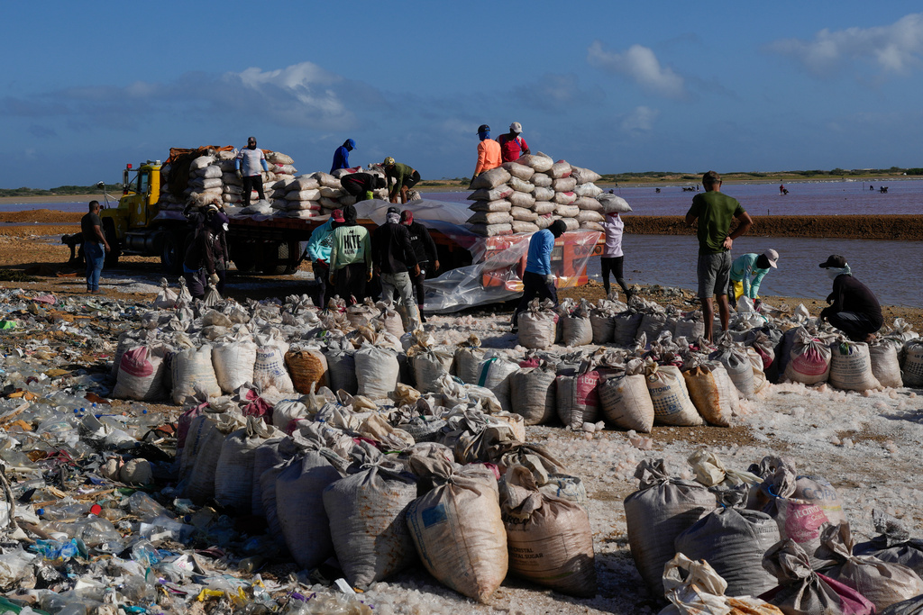 People work at the Salinas de Cumaraguas salt flats on the Paraguana Peninsula, Venezuela, Thursday, Jan. 15, 2026. (AP Photo/Matias Delacroix)