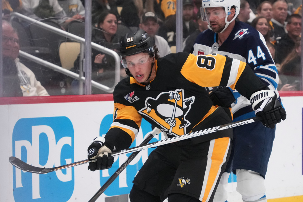 Pittsburgh Penguins' Ben Kindel (81) is defended by Winnipeg Jets' Josh Morrissey (44) during the second period of an NHL hockey game in Pittsburgh, Monday, Oct. 5, 2026. (AP Photo/Gene J. Puskar)