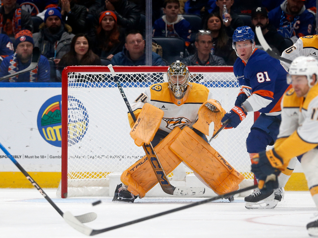 Nashville Predators goalie Juuse Saros, left, guards the net as New York Islanders forward Ondrej Palat stands in front during the third period of an NHL hockey game Saturday, Jan. 31, 2026, in Elmont, N.Y. (AP Photo/John Munson)
